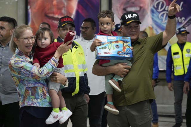 Venezuela's Interior Minister Diosdado Cabello, right, and First Lady Cilia Flores welcome children of Venezuelan migrants, whose parents were deported separately from the United States, at Simon Bolivar International Airport in Maiquetia, Venezuela, Friday, July 18, 2025. (AP Photo/Ariana Cubillos)