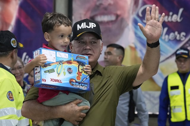Venezuela's Interior Minister Diosdado Cabello welcomes children of Venezuelan migrants, whose parents were deported separately from the United States, at Simon Bolivar International Airport in Maiquetia, Venezuela, Friday, July 18, 2025. (AP Photo/Ariana Cubillos)