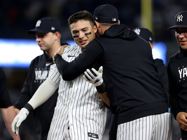 NEW YORK, NEW YORK - MAY 23: Anthony Volpe #11 of the New York Yankees is congratulated by manager Aaron Boone after Volpe drove in the game winning run with a sacrifice fly against the Baltimore Orioles at Yankee Stadium on May 23, 2023 in Bronx borough of New York City. The New York Yankees defeated the Baltimore Orioles 6-5 in 10 innings.