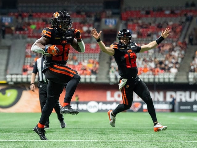 B.C. Lions' James Butler (20) scores a touchdown against the Edmonton Elks as B.C. Lions quarterback Nathan Rourke (12) cheers during the second half of a CFL football game in Vancouver, on Saturday, June 7, 2025.