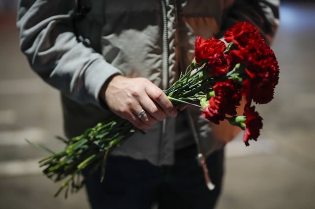 FILE; A man holds a bunch of red carnations in Istanbul, Turkey, Friday, Feb. 16, 2024. 