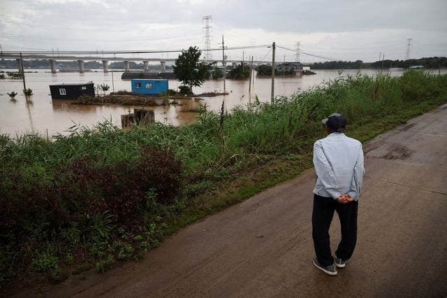 Lee Han-seob looks at his house, submerged during flooding caused by torrential rain, in Yesan, South Korea, July 18, 2025. REUTERS/Kim Hong-Ji/File Photo