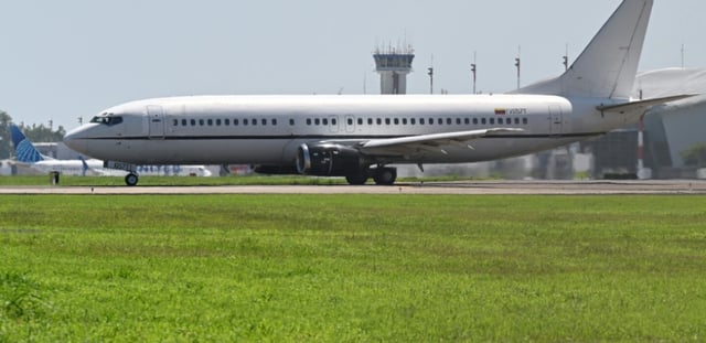 Un avion transportant des migrants vénézuéliens emprisonnés au Salvador roule sur la piste avant de partir en direction du Venezuela, sur le tarmac de l'aéroport international San Oscar Romero à San Luis Talpa, au Salvador, le 18 juillet 2025