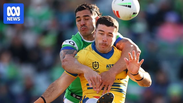 A man kicks the ball during a rugby league match 