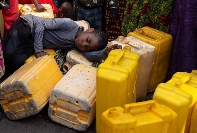 A child sleeps on plastic jerrycans as people queue at the standpipe, where incomplete water connections caused by USAID funding cuts to the NGO Mercy Corps have led to ongoing water shortages, in Goma, North Kivu province, Democratic Republic of Congo, June 16, 2025. REUTERS/Arlette Bashizi/File Photo
