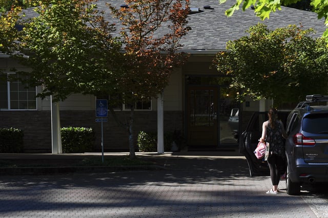 A guardian drops off a child at the Guidepost Montessori school on Friday, July 18, 2025, in Beaverton, Ore. (AP Photo/Jenny Kane)