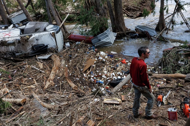 Travis Kuehler from New Braunfels pauses to catch his breath while helping to clear a large pile of debris at the Guadalupe Keys RV Resort, situated along the banks of the Guadalupe River in Center Point, on Tuesday, July 8, 2025.