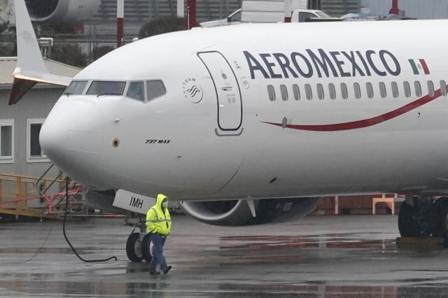 A worker wearing a mask walks past a Boeing 737 Max 9 built for Aeromexico as it is prepared for a flight from Renton Municipal Airport, Wednesday, Nov. 18, 2020, in Renton, Wash. After nearly two years and a pair of deadly crashes, the U.S. Federal Aviation Administration announced Wednesday that the 737 Max has been cleared for flight after regulators around the world grounded the Max in March 2019, after the crash of an Ethiopian Airlines jet. (AP Photo/Ted S. Warren)