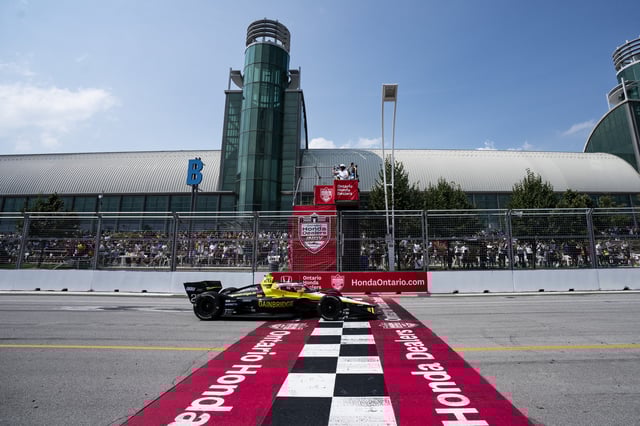 Colton Herta (26) of the United States crosses the finish line to win the 2024 Ontario Honda Dealers Indy, in Toronto on Sunday, July 21, 2024. THE CANADIAN PRESS/Arlyn McAdorey