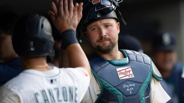 Jul 19, 2025; Seattle, Washington, USA;  Seattle Mariners right fielder Dominic Canzone (8), left, is congratulated by catcher Cal Raleigh (29) in the dugout after hitting a two-run double during the third inning against the Houston Astros at T-Mobile Park. Mandatory Credit: Stephen Brashear-Imagn Images