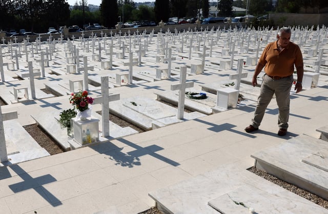 A man walks next to the graves of soldiers killed in the 1974 Turkish invasion of Cyprus at the Tymvos Makedonitissas military cemetery in Nicosia, Cyprus July 20, 2025. REUTERS/Yiannis Kourtoglou