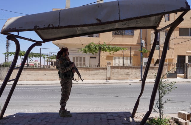 A member of the Syrian security forces stands along a street, after clashes between Syrian government troops and local Druze fighters resumed in the southern Druze city of Sweida early on Wednesday, collapsing a ceasefire announced just hours earlier that aimed to put an end to days of deadly sectarian bloodshed, in Sweida, Syria July 16, 2025. REUTERS/Karam al-Masri/File Photo