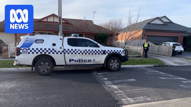 A house with a police car and police officer standing out the front.