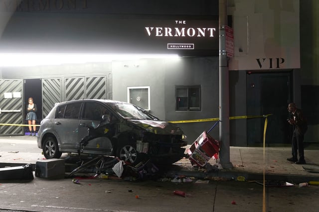 A vehicle sits on the sidewalk after ramming into a crowd of people waiting to enter a nightclub along a busy boulevard in Los Angeles early Saturday, injuring several people.