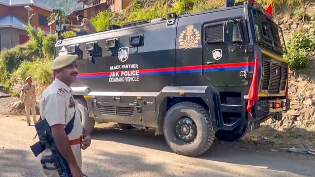 A police official stands guard amid tight security during an ongoing anti-terror operation, in Kishtwar, Jammu and Kashmir.