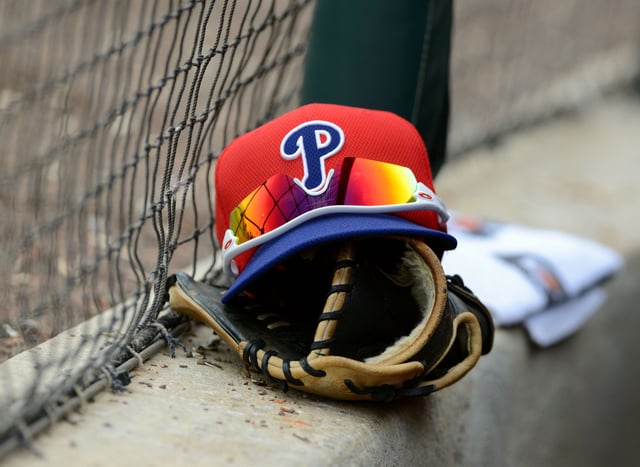 A detailed view of a Philadelphia Phillies baseball hat and glove sitting in the dugout during the spring training game against the Detroit Tigers at Joker Marchant Stadium on February 24, 2013.