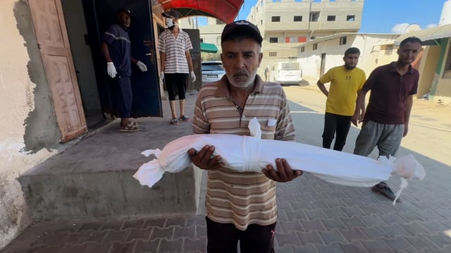 Razan Abu Zaher’s shrouded body is carried after she died from malnutrition.