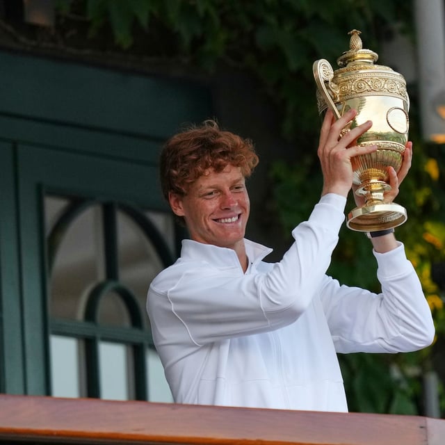 Italy's Jannik Sinner shows the trophy from the balcony of Centre Court after beating Carlos Alcaraz of Spain to win the men's singles final at the Wimbledon Tennis Championships in London, Sunday, July 13, 2025. (AP Photo/Joanna Chan)
