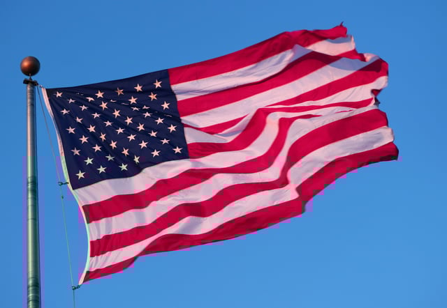 The sun sets on an American flag flying at Liberty State Park on March 4, 2021 in Jersey City, New Jersey. 