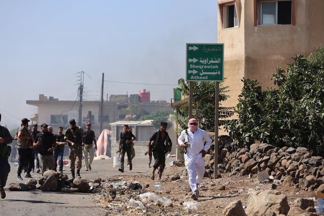 Combatientes beduinos avanzando por el poblado de Wolgha, en la campiña occidental de Sweida, en el sur de Siria