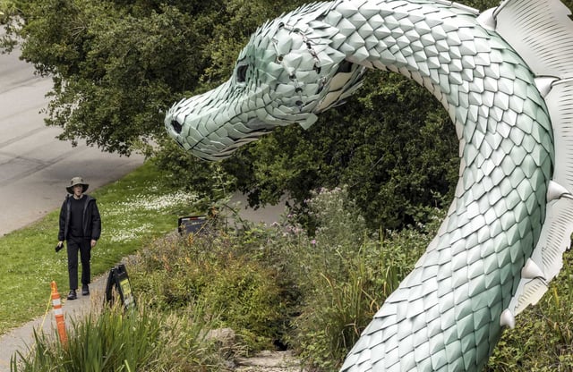 Visitors to Golden Gate Park stop to admire the Naga sea serpent sculpture being installed at Rainbow Falls. The sculpture will be illuminated on Monday evening, July 28.