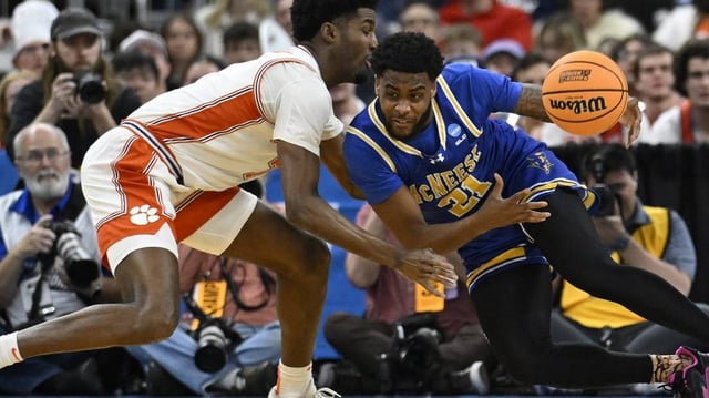 Mar 20, 2025; Providence, RI, USA; McNeese State Cowboys guard Sincere Parker (21) drives against Clemson Tigers forward Chauncey Wiggins (7) during the first half at Amica Mutual Pavilion. Mandatory Credit: Eric Canha-Imagn Images