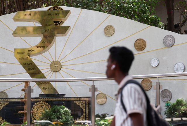 A man walks past an installation of the Rupee logo and Indian currency coins outside the Reserve Bank of India (RBI) headquarters in Mumbai, India, April 9, 2025. REUTERS/Francis Mascarenhas/ File Photo