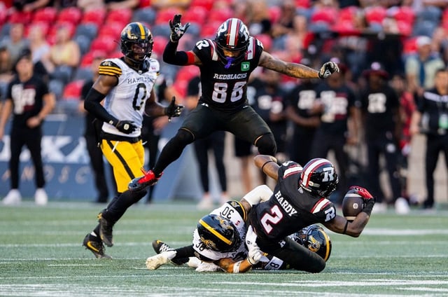 Ottawa Redblacks wide receiver Andre Miller leaps over teammate wide receiver Justin Hardy as he is tackled by Hamilton Tiger-Cats defensive back Stavros Katsantonis on Sunday. Spencer Colby/THE CANADIAN PRESS