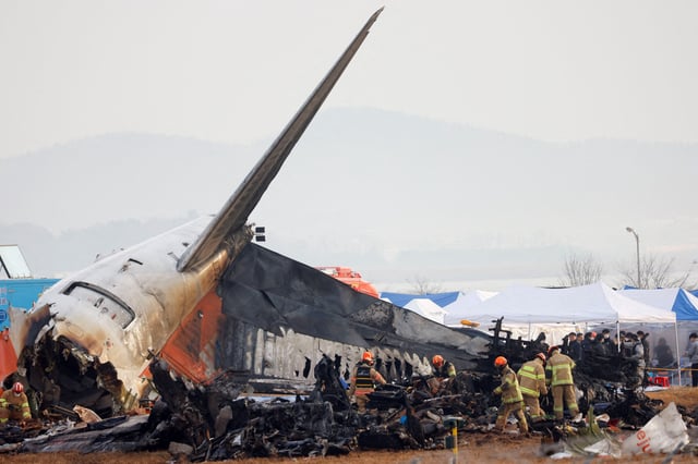 People work at the site where an aircraft went off the runway and crashed at Muan International Airport, in Muan, South Korea, December 30, 2024. REUTERS/Kim Soo-hyeon/File Photo