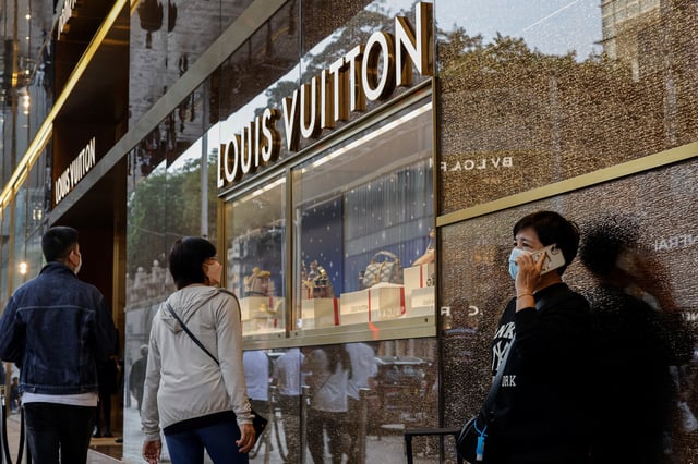 People walk past a Louis Vuitton store in Tsim Sha Tsui, a bustling shopping hotspot, in Hong Kong, China December 5, 2023. REUTERS/Tyrone Siu/ File Photo