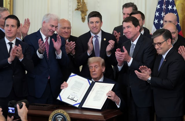 President Donald Trump, surrounded by lawmakers, signs the GENIUS Act into law during a ceremony in the East Room of the White House July 18, 2025, in Washington, D.C. (Photo by Anna Moneymaker/Getty Images)