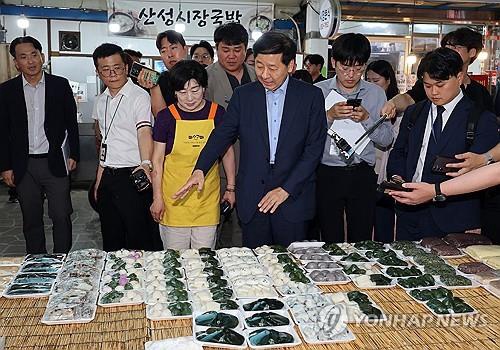 Finance Minister Koo Yun-cheol (front, C) visits a traditional market in Gongju, South Chungcheong Province, on July 21, 2025. (Yonhap)