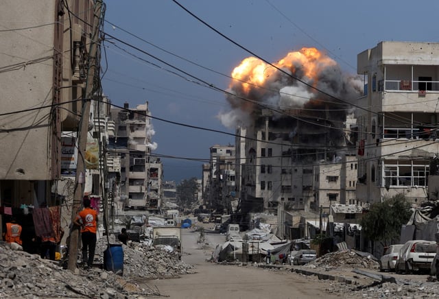 Smoke and flames rise from a residential building hit by an Israeli strike, in Gaza City July 21, 2025. REUTERS/Khamis Al-Rifi     TPX IMAGES OF THE DAY
