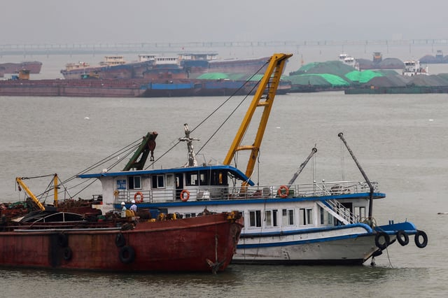A tourist boat (in white) that capsized in an accident which killed dozens and left several people still missing, is towed back to the port in Halong Bay, Quang Ninh province, Vietnam, July 20, 2025. REUTERS/Thinh Nguyen