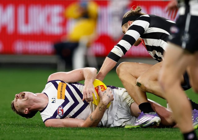 Collingwood defender Darcy Moore has avoided a sanction for dropping his knees into Josh Treacy on Sunday.
