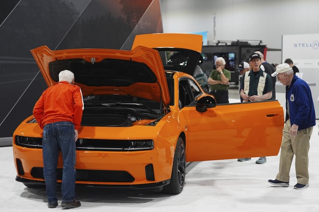 FILE - Shoppers look over a 2025 Dodge Charger Daytona hardtop in the Stellantis display at the Colorado Auto Show, April 17, 2025, in Denver. (AP Photo/David Zalubowski, File)