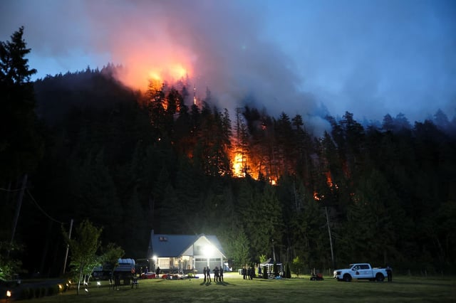 Des pompiers surveillent un feu de forêt grandissant à Squamish, au Canada, le 9 juin 2025.
