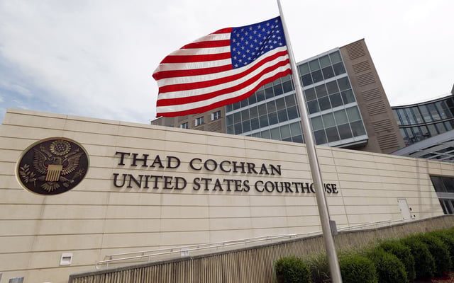 FILE - An American flag flies at half-staff outside the Thad Cochran United States Courthouse in downtown Jackson, Miss., on May 30, 2019. (AP Photo/Rogelio V. Solis, File)