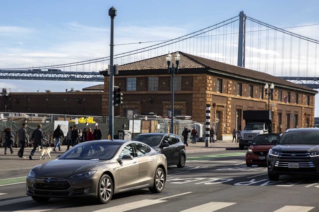 A person drives a Tesla Model S on the Embarcadero in 2019. The car company is having a hearing this week with California&#39;s DMV, about Tesla&#39;s claims of self-driving abilities with its cars.