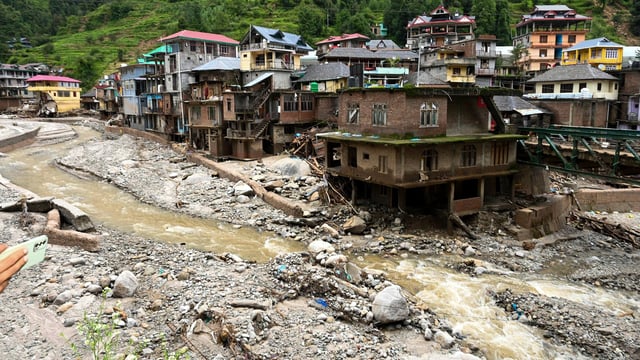 Debris and slit near damaged houses at a flood-affected area, in Mandi district.