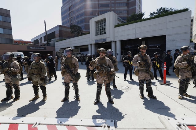Marines and police stand outside the Metropolitan Detention Center on Friday, July 4, 2025 in Los Angeles. (AP Photo/Jill Connelly)
