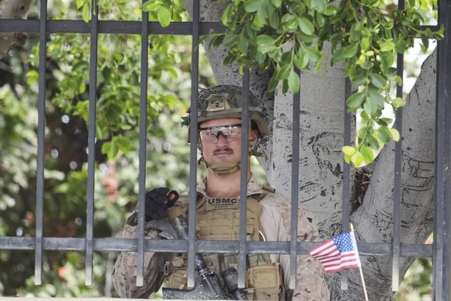 A U.S. Marine stages outside a business park on Monday, June 23, 2025, in Paramount, Calif. (AP Photo/Damian Dovarganes)