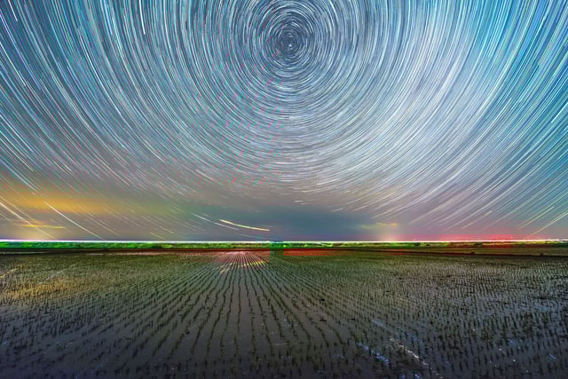 This stack composite photo shows a paddy rice field under the starry sky in Shuangyashan City, northeast China's Heilongjiang Province, May 25, 2025. With paddy rice transplanting largely concluded in Heilongjiang, the vast black soil in the province is now dressed in green, hinting the hope for a bountiful harvest. The Milky Way spreading across a starry sky is mirrored in waterlogged paddy rice fields, making a breathtaking scene in the early summer night. (Photo by Qu Yubao/Xinhua via Getty Images)