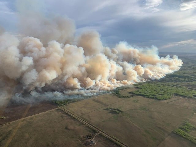 This aerial handout picture courtesy of the Alberta Wildfire Service, taken May 10, 2024, shows smoke from wildfires burning in the Grande Prairie forest area, four kilometres east of the town of Teepee Cree.