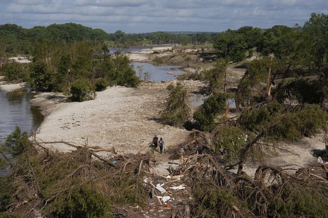 FILE - Search and rescue teams from Kerrville Fire Department walk past debris after flooding near the banks of the Guadalupe River in Kerrville, Texas, on Tuesday, July 8, 2025. (AP Photo/Ashley Landis, File)