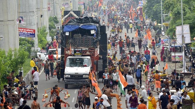 People, accompanied by loud DJ music, carry holy water on the Ghaziabad-Delhi Meerut road as part of the Kanwar Yatra on Monday. (Sakib Ali/ HT Photo)