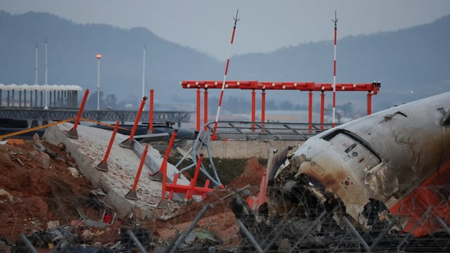 The wreckage of the Jeju Air aircraft that went off the runway and crashed at Muan International Airport lies near a concrete structure, as shown on Dec. 30, 2024. 