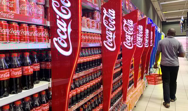 A man walks past shelves of Coca-Cola bottles and cans at a shopping mall in Lagos, Nigeria November 5, 2019.