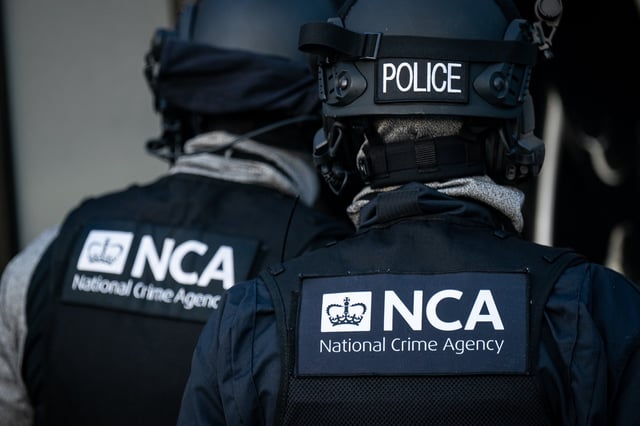 Officers from the National Crime Agency arrive at a property of a man who is accused of being a member of a group arranging small boat crossings and HGV journeys for migrants, in Grays , Essex. (Photo by Aaron Chown/PA Images via Getty Images)