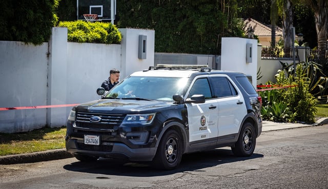 Los Angeles Police Department officials secure the home where Robin Kaye, an "American Idol" music supervisor, and her husband, Thomas Deluca, were found killed in Encino, California.